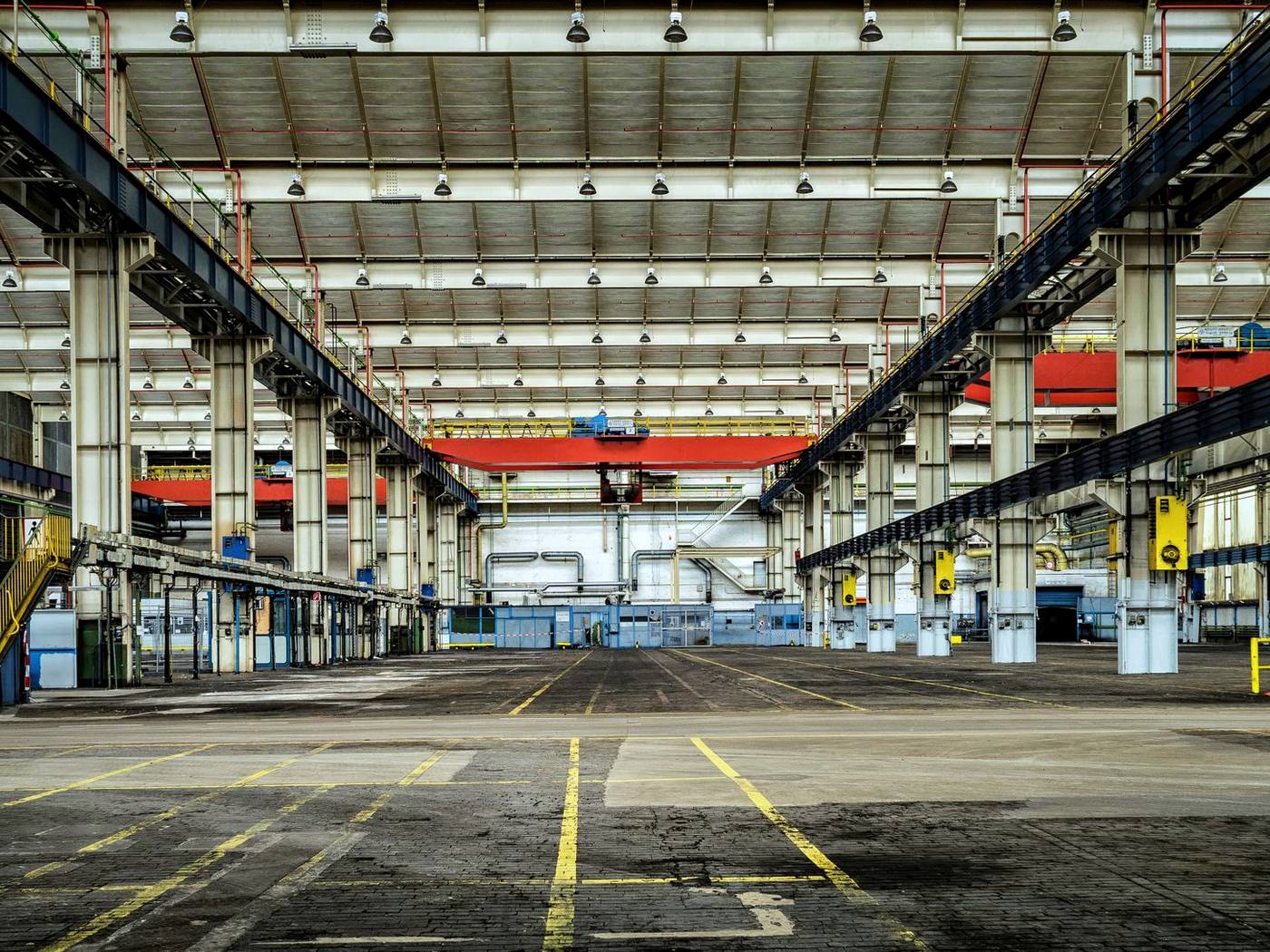 Innenansicht einer großen Produktionshalle mit Stahlfachwerk und Kranbahnen