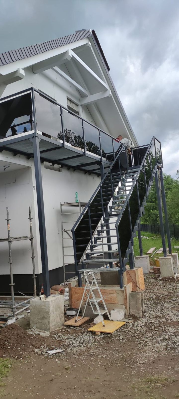 Balkon mit Außentreppe auf vorbereiteten Fundamenten während der Montage