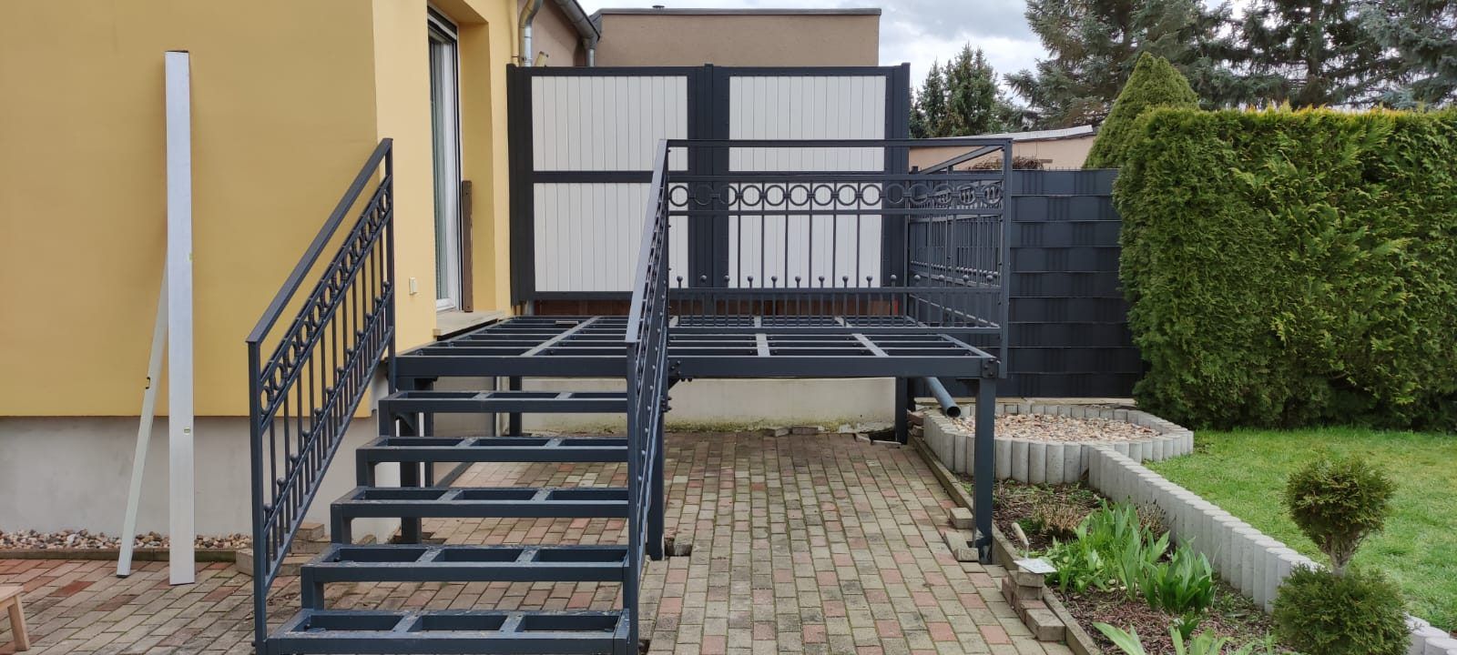 Stahlpodest mit Treppe und Ziergeländer an einem Wohnhaus