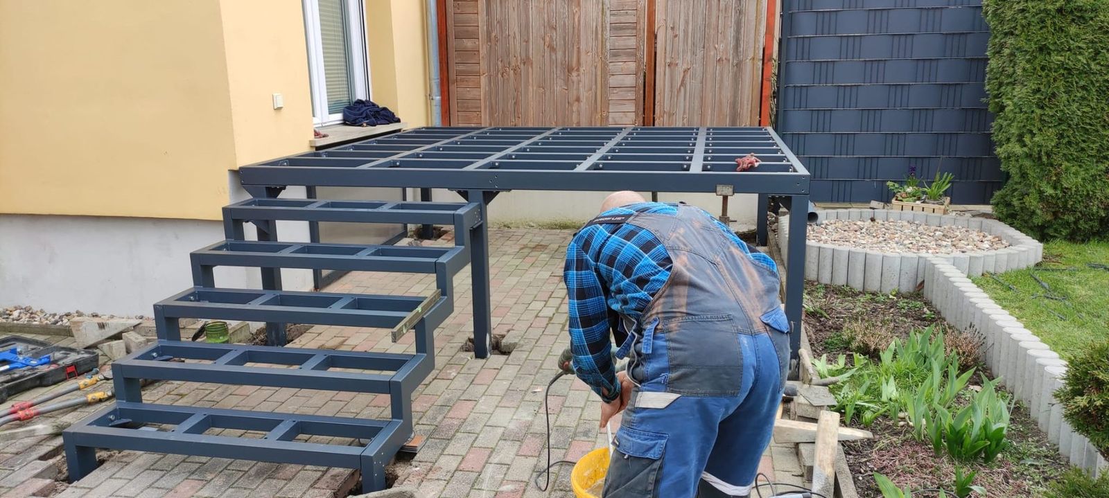 Monteur beim Aufbau eines Stahlpodests mit Treppe
